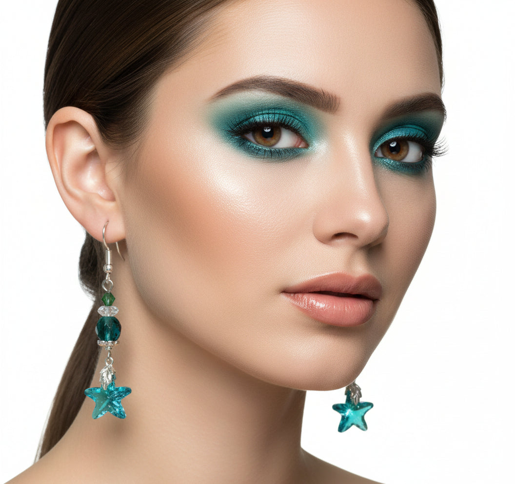 Star-shaped blue earrings with green and silver beads on a branch background