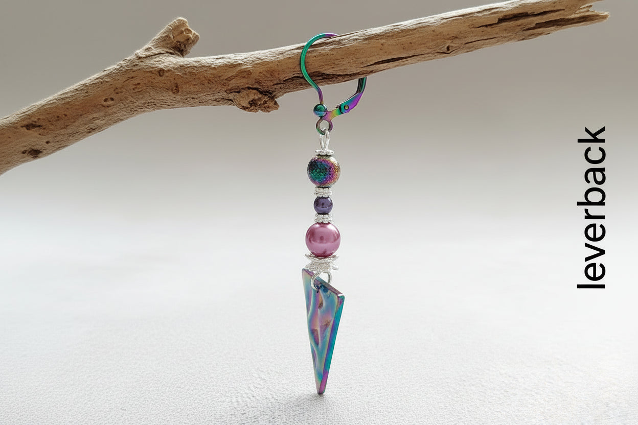 Colorful triangle-shaped earrings with beads hanging on a branch.