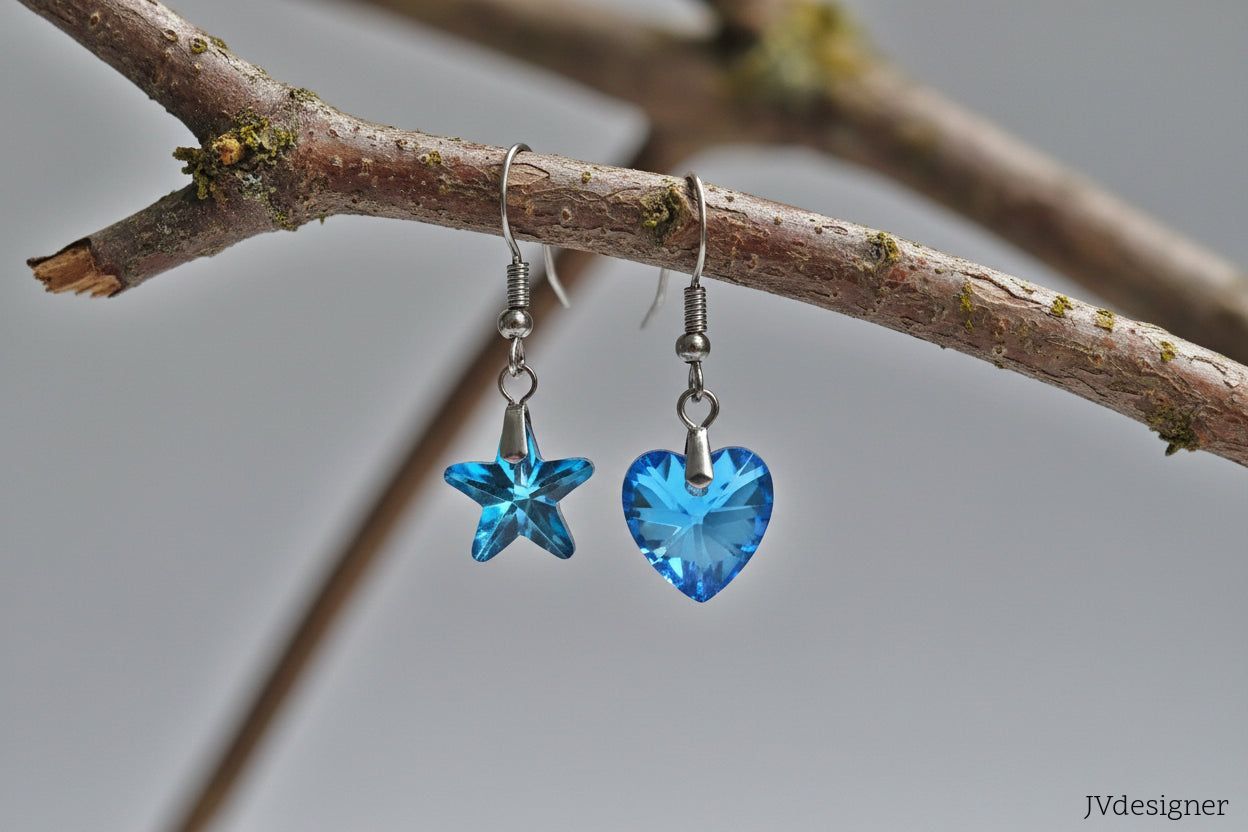 Blue heart and starfish earrings hanging from a branch.