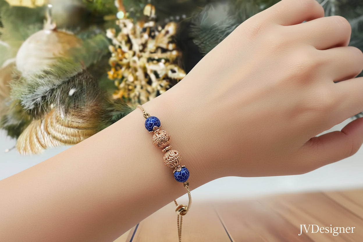 Bracelet with blue and gold beads on a wooden surface with a Christmas tree in the background