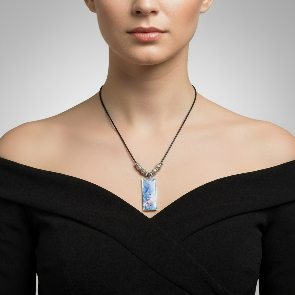 Necklace with a blue pendant featuring floral designs on a gray background