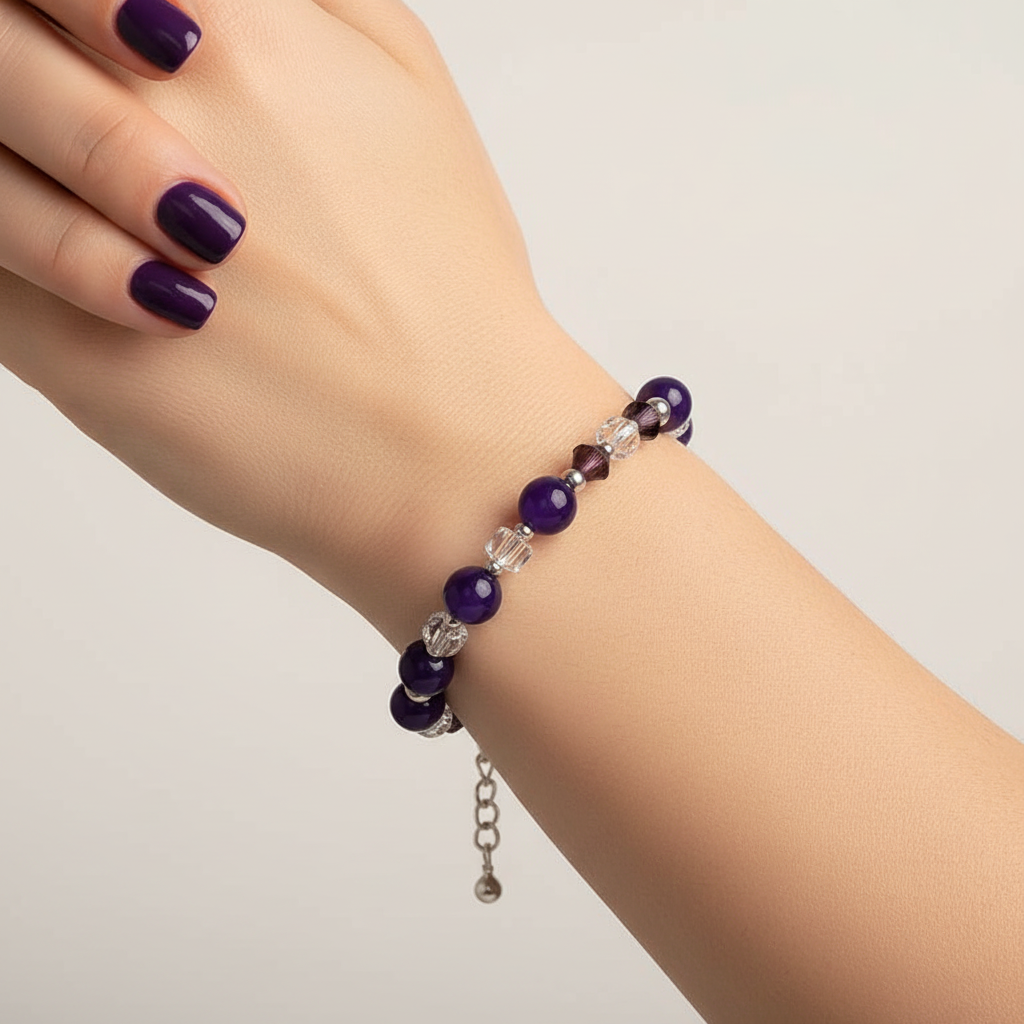 Beaded bracelet with purple and clear beads on a white cube
