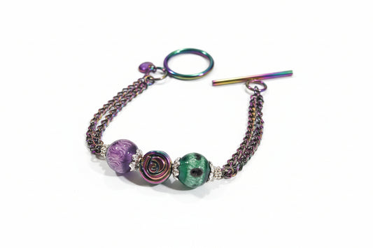 Bracelet with colorful beads and chain on a textured surface