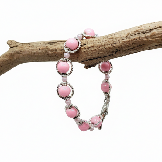 Bracelet with pink beads and silver accents on a white background