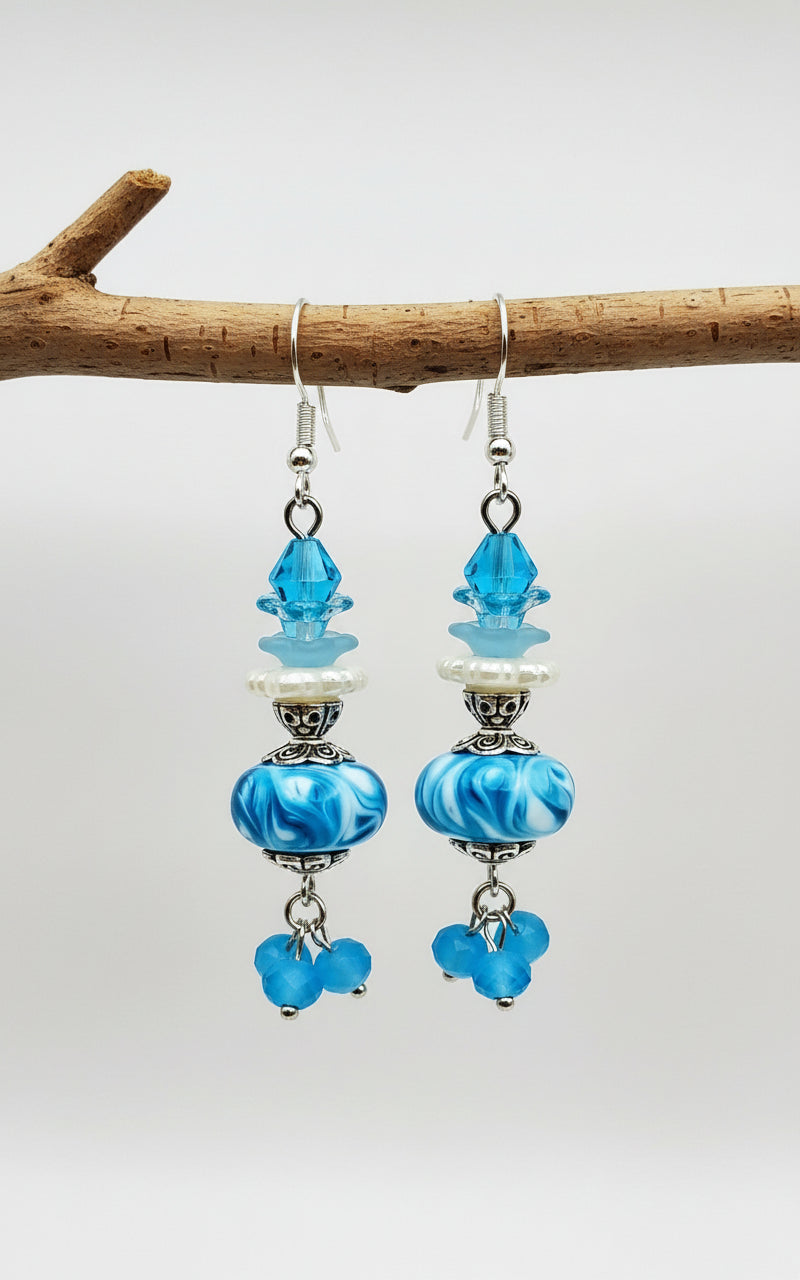 Blue glass bead earrings with silver accents on a white background