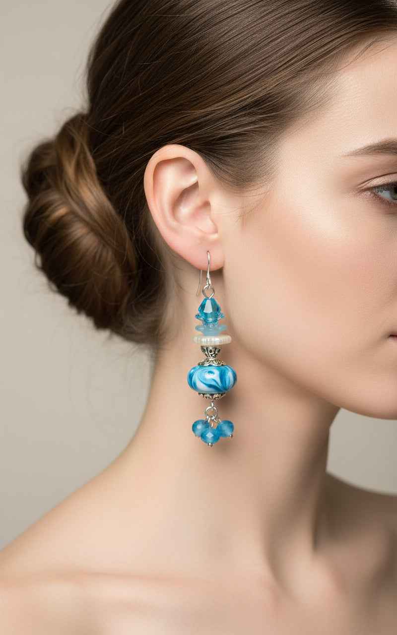 Blue glass bead earrings with silver accents on a white background