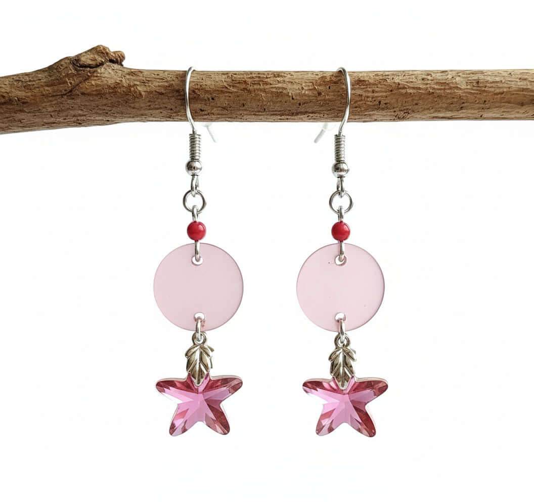Pink star-shaped earrings with round pink beads on a white background