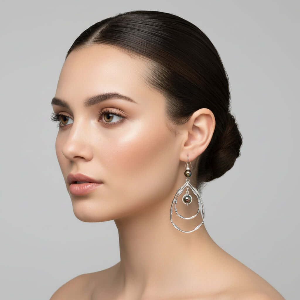 Pair of silver teardrop earrings with colorful beads on a white card.