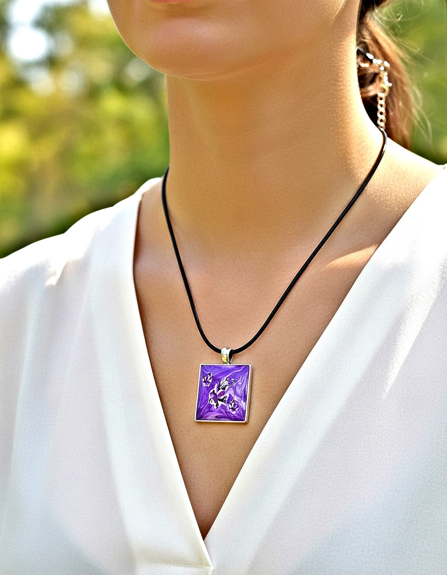 Person wearing a necklace with a purple pendant outdoors