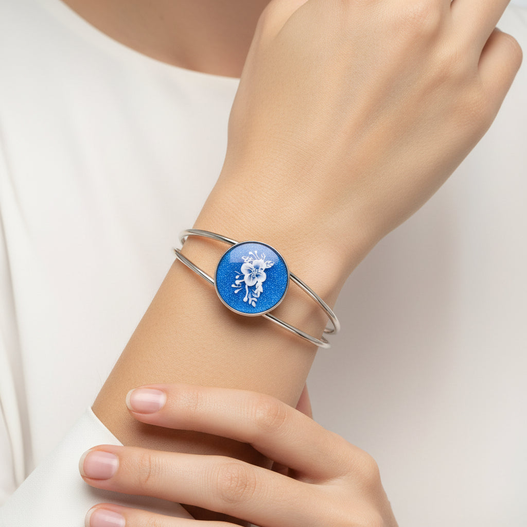 Silver bracelet with a blue round charm featuring a white deer design on a white background
