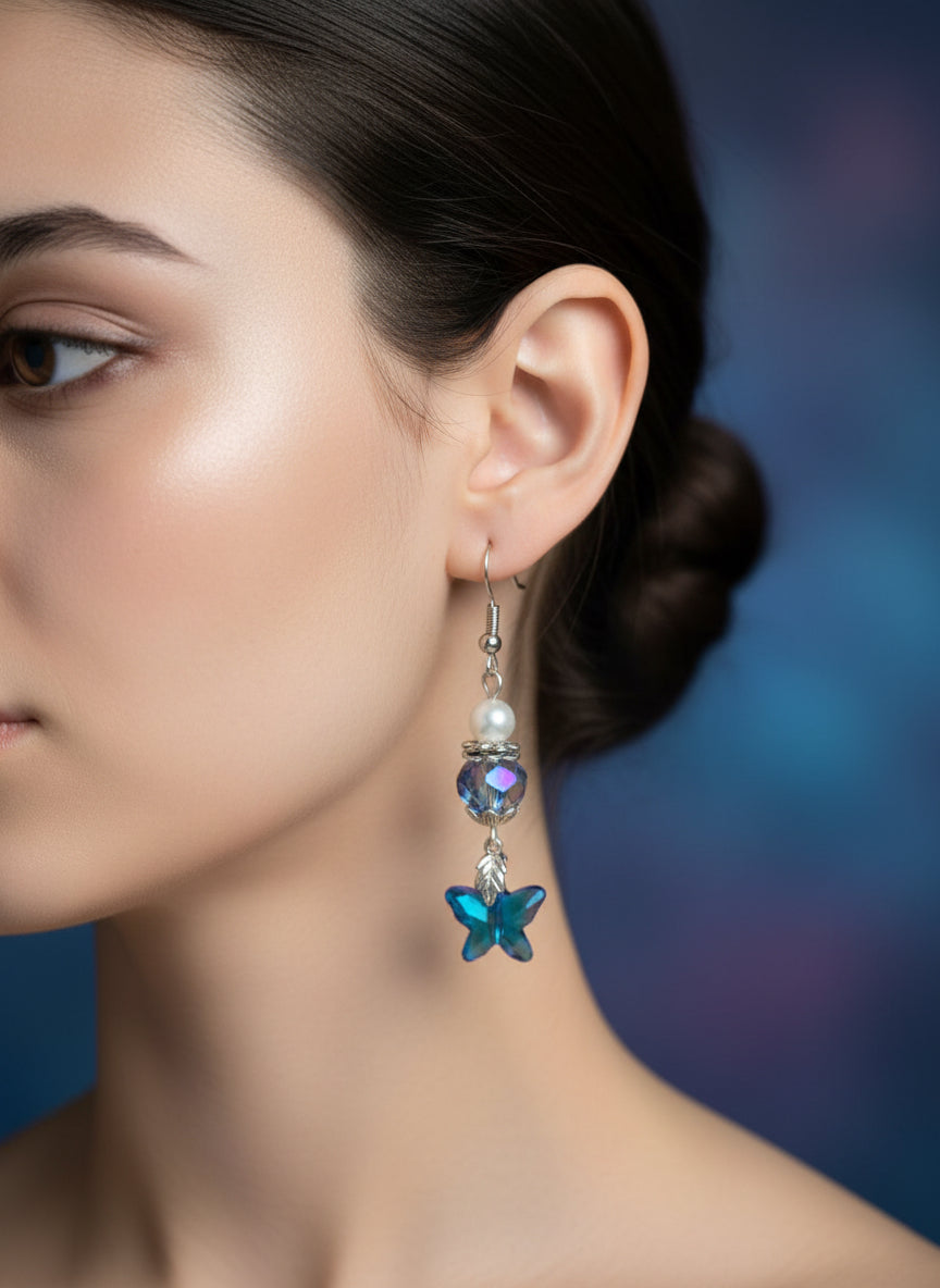 Pair of earrings with blue starfish and beaded design on a dark surface