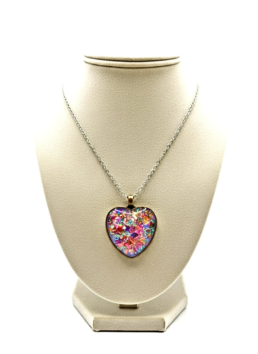 Necklace with a colorful heart-shaped pendant on a beige display stand.