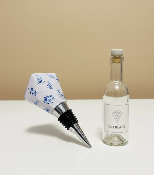 Bottle stopper with blue floral design on a white background