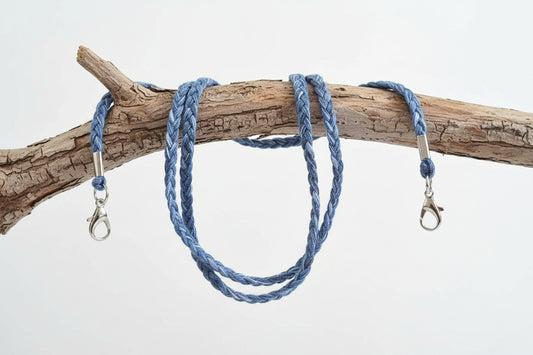 Blue braided lanyard with metal clasps on a wooden branch against a white background