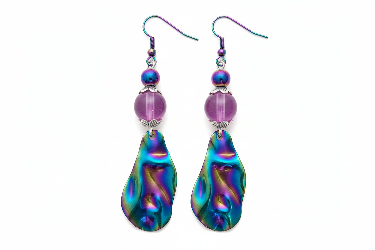 Multicolored teardrop earrings with purple beads on a beige background