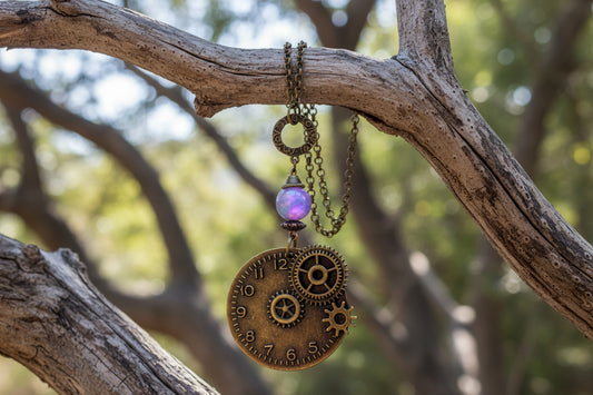 Steampunk-style necklace with gears and a blue bead on a light background