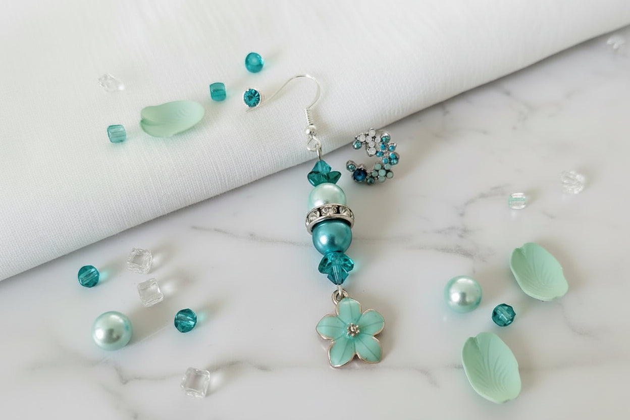 Turquoise beaded earrings with floral design on a textured surface