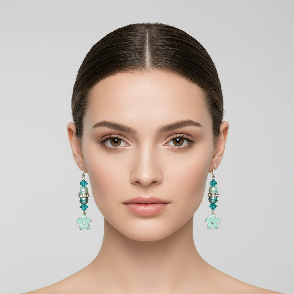 Turquoise and pearl beaded earrings on a marble surface with scattered pearls and flowers.