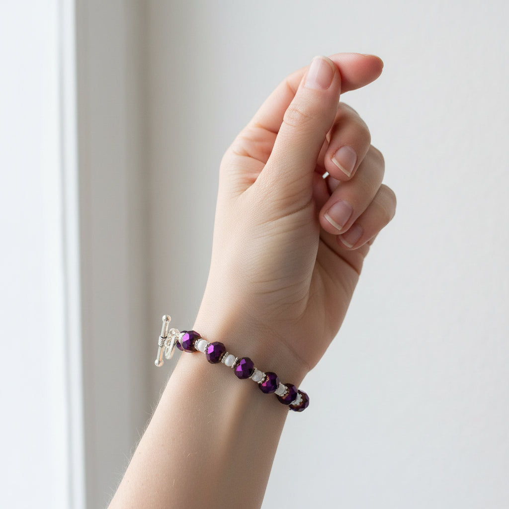 Beaded bracelet with purple and white beads on a gray background