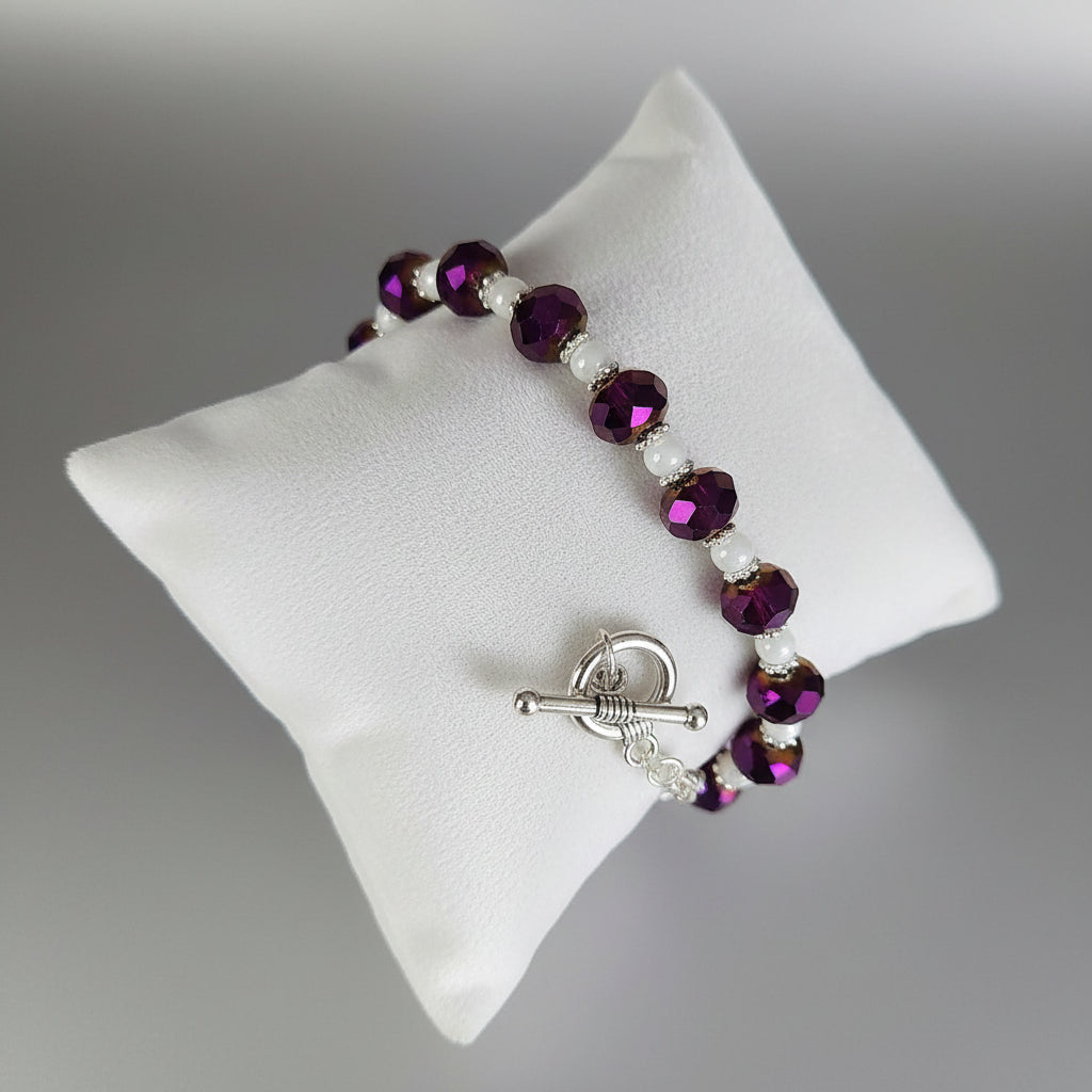 Beaded bracelet with purple and white beads on a gray background