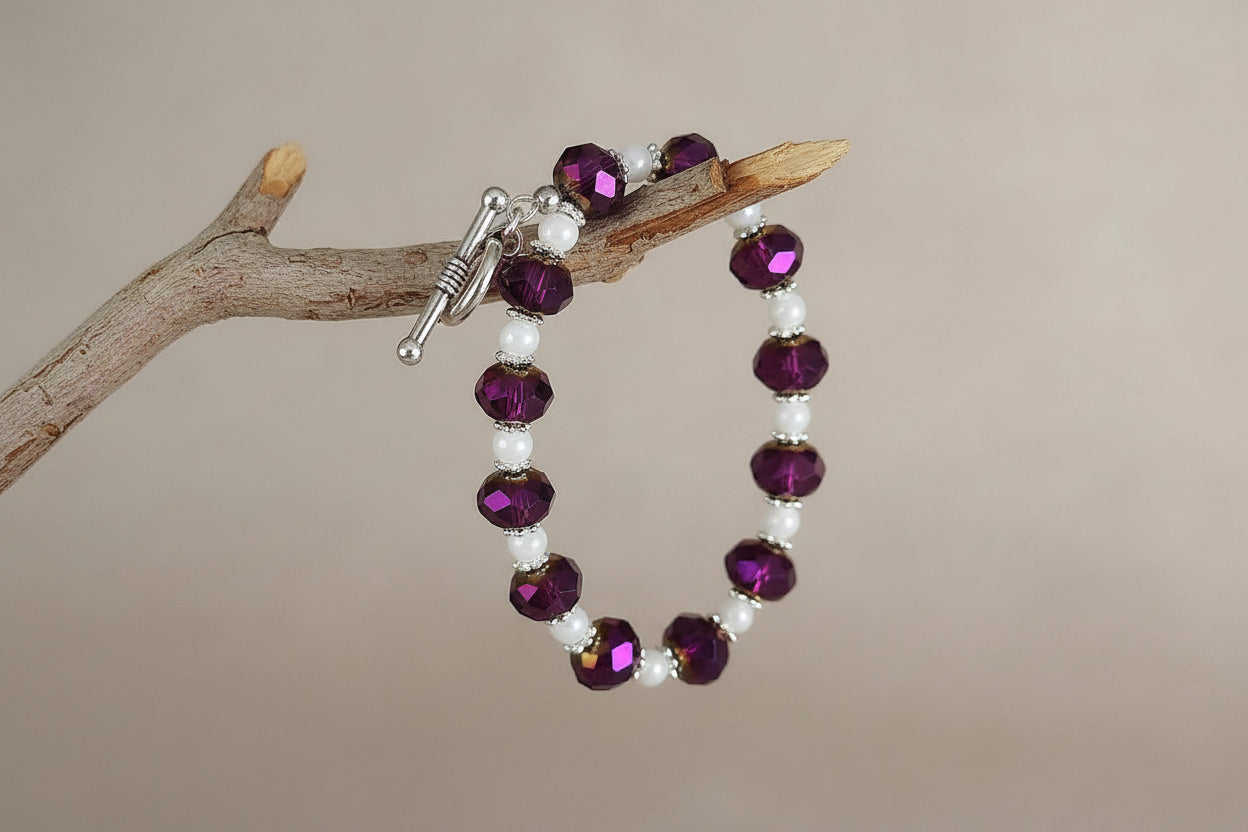 Beaded bracelet with purple and white beads on a gray background