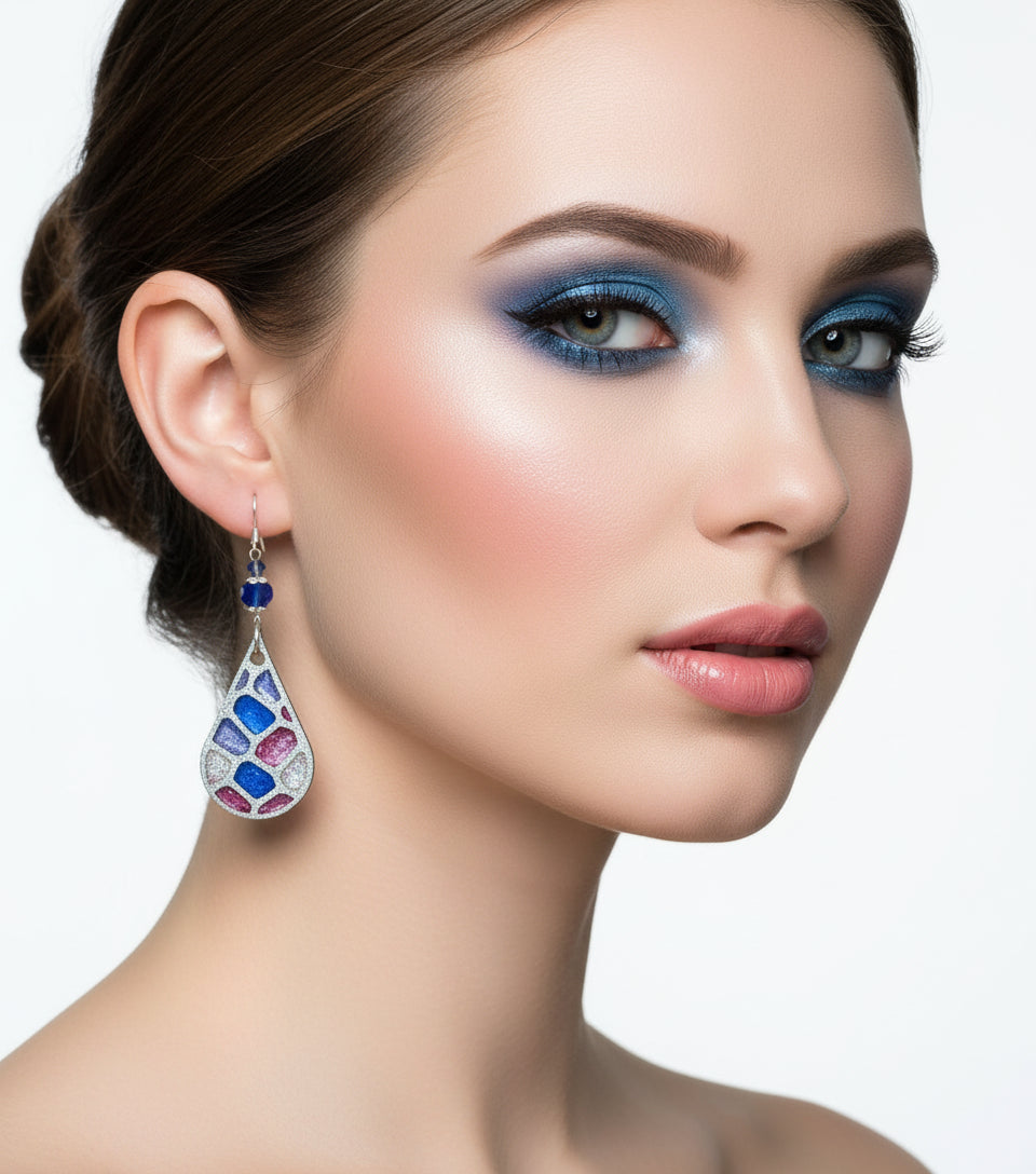 Teardrop-shaped earrings with colorful bead designs hanging from a branch.