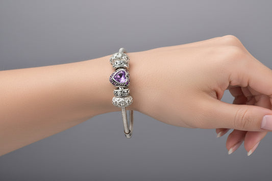 Silver bracelet with a purple heart charm on a light gray background