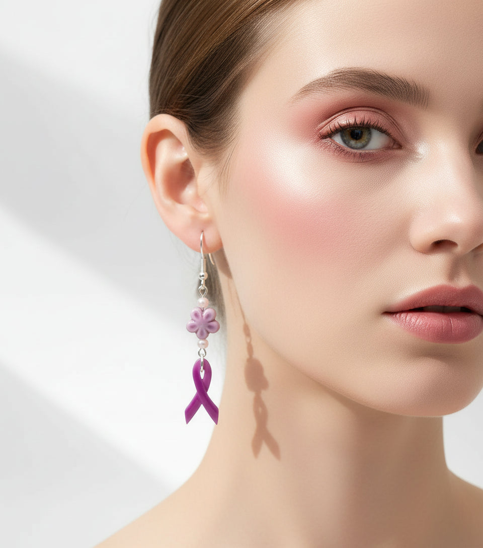 Purple ribbon earrings with floral elements hanging on a branch against a white background