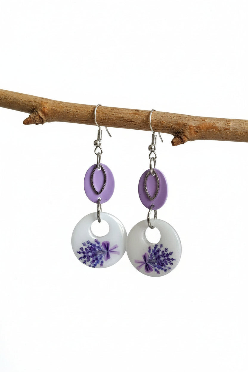 Pair of earrings with purple floral design on a white background