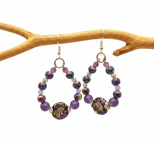 Beaded earrings with colorful beads and gold accents on a yellow background
