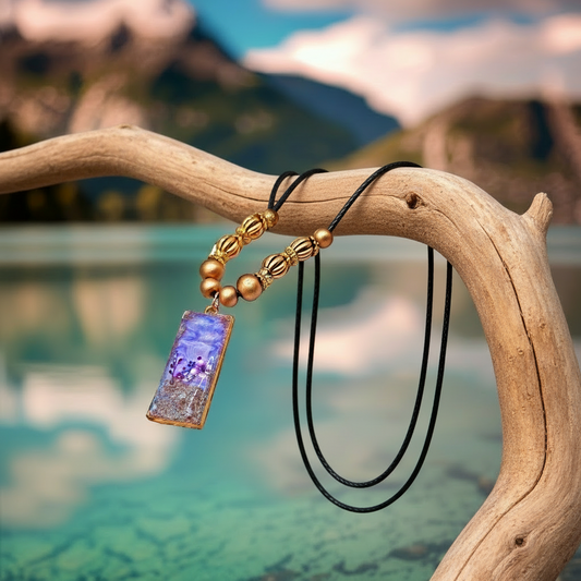 Necklace with a purple pendant on a branch by a blurred natural background