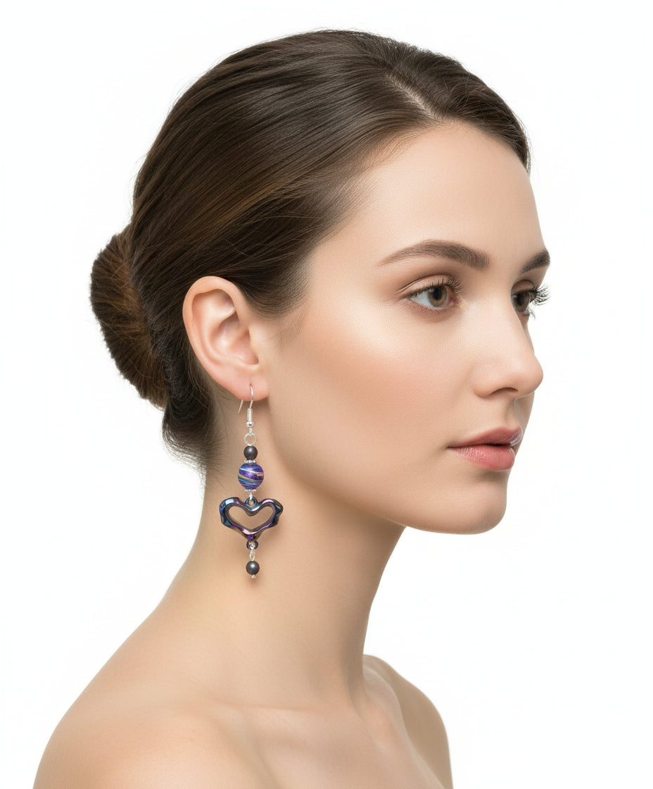 Heart-shaped earrings with colorful beads hanging from a branch.