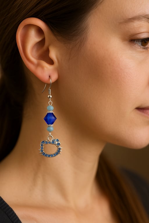 Close-up of a woman wearing a blue cat-shaped earring.