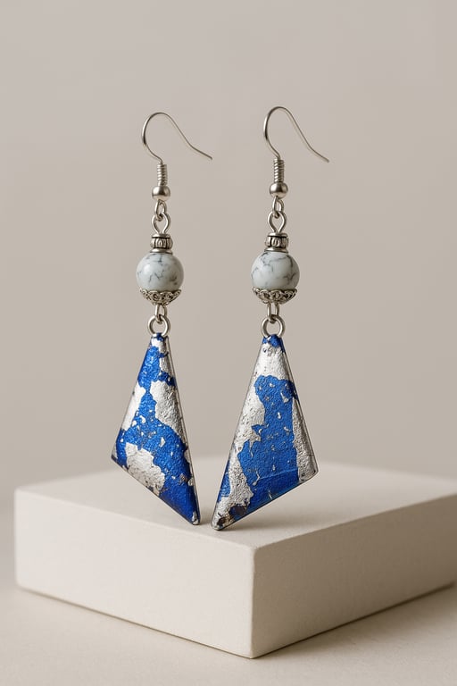 Pair of blue and silver geometric earrings on a beige background