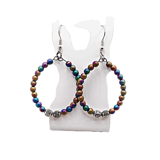 Multicolored beaded hoop earrings on a white mannequin bust.